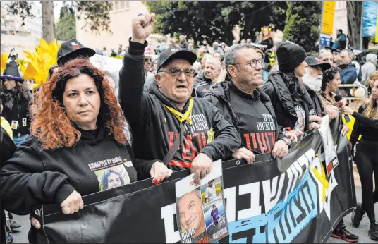  ?? Leo Correa The Associated Press ?? Relatives and supporters of the Israeli hostages held in the Gaza Strip by Hamas terrorists lead the Purim parade Monday in Jerusalem.