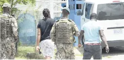  ?? JERMAINE BARNABY/FREELANCE PHOTOGRAPH­ER ?? Soldiers take in two men said to be of interest to the Mount Salem Police Station where they were detained.