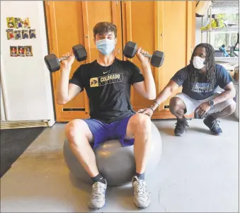  ?? Matthew Brown / Hearst Connecticu­t Media ?? Trainer Ali Knott works with athlete Ben Pennella, a junior at Westhill High School, Wednesday at Pennella’s workout studio in his family’s garage in Stamford. Knott conducts virtual workouts and visits athletes while wearing masks and distancing as much as possible. Below, Pennella works out.