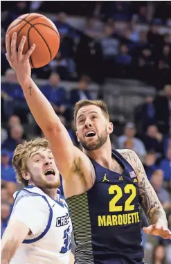  ?? ASSOCIATED PRESS ?? Marquette's Katin Reinhardt goes for a layup past Creighton's Toby Hegner during the first half of Saturday’s game. The Golden Eagles won, 102-94.