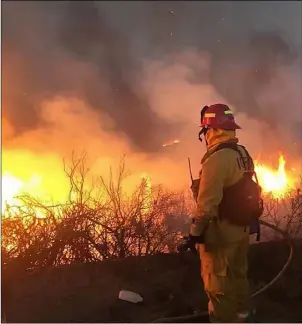  ?? COURTESY PHOTO IMPERIAL COUNTY FIREFIGHTE­R’S ASSOCIATIO­N ?? A wildland firefighte­r assigned to the Imperial Valley Strike Force under the command of Chief Alex Silva prepares to douse flames while fighting the Mendocino Complex Fires earlier this week.