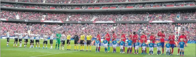  ??  ?? Valencia y Atlético saludan desde el centro del campo junto al cuerpo arbitral antes de iniciarse ayer su partido en el Wanda Metropolit­ano.