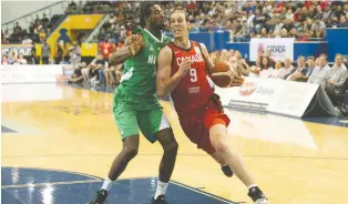  ?? CHRIS YOUNG/THE CANADIAN PRESS ?? Canada’s Kelly Olynyk drives past Nigeria’s Alade Aminu during an internatio­nal exhibition game on Wednesday in Toronto. Olynyk hurt his knee and left the game in the third quarter.