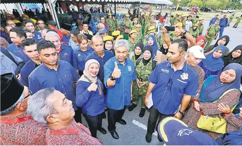  ?? — Photo by Chimon Upon ?? Ahmad Zahid and Nancy give the thumbs-up upon their arrival at the Dewan Daerah Simunjan during the former’s walkabout programme.