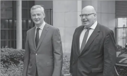  ?? PARIS
-AFP ?? Bruno Le Maire, France's finance minister, left, walks alongside Peter Altmaier, Germany's acting finance minister, as he arrives ahead of a news conference.