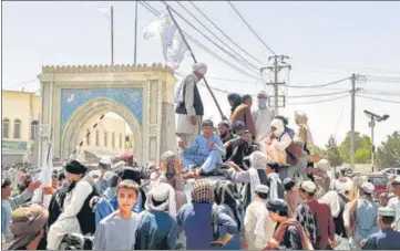  ?? AFP ?? Taliban fighters are seen standing atop a vehicle in the city of Kandahar, Afghanista­n, on Friday.