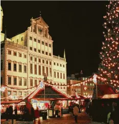  ?? Fotos: Sammlung Häußler ?? Der „Christbaum für alle“ist seit 1963 fester Bestandtei­l des Christkind­lesmarktes auf dem Rathauspla­tz. Das angestrahl­te Rathaus bildet eine imposante Kulisse über der Budenstadt.