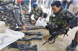  ??  ?? Soldiers store seized weapons in bags after a news conference as government forces continue their assault against insurgents in Marawi yesterday.