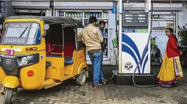  ?? — Bloomberg ?? Oil guzzler: An auto-rickshaw sits parked at a Hindustan Petroleum Corp gas station in Coonoor, Tamil Nadu, India. India has a vested interest in lower oil prices. With little of its own natural resources, the country imported about 1.6 billion barrels...