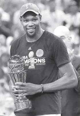  ?? / AP Photo ?? ■ FINALS MVP. Nagpahiyom si Golden State Warriors forward Kevin Durant sa paggunit niya sa iyang Bill Russell NBA Finals Most Valuable Player Award human sa NBA Finals kagahapon.