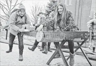  ?? IAN STEWART SPECIAL TO THE RECORD ?? Sean McLeod leans into the crosscut blade during the two-man log-cutting competitio­n, while Robyn Hartley steadies the end for the aspiring lumberjack at the Elmira Maple Syrup Festival on Saturday.