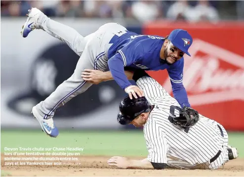  ??  ?? Devon Travis chute sur Chase Headley lors d’une tentative de double jeu en sixième manche du match entre les Jays et les Yankees hier soir.