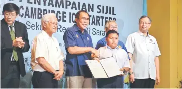  ??  ?? Len Talif (third left) presents the CIS certificat­e to one of the pupils, witnessed by (from left) Ng, Abdul Hamed, Sikie and Wan Liz Ozman.