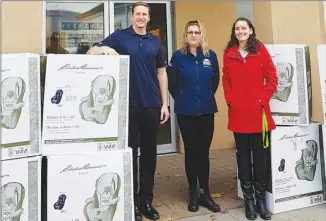  ?? AMANDA HARRETT/Special to The Herald ?? Ian Gerbrandt and Tracy Ingbritson from the Penticton and District Community Resources Society, along with the United Way’s Reanne Amadio, unload 10 new car seats that will be donated to local families in need.