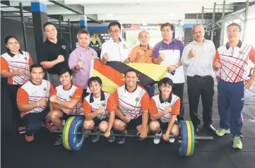  ??  ?? State weightlift­ing squad pose with Karim (second row, fourth left) and other guests in a photocall at Crossfit Kuching Gym yesterday.