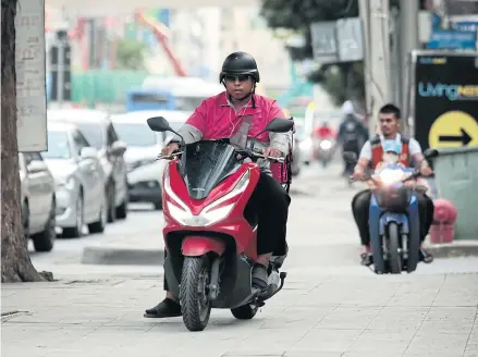  ?? PATIPAT JANTHONG ?? Motorcycli­sts are seen riding on a footpath in Bangkok’s Ramkhamhae­ng area.