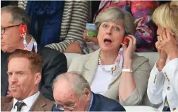  ??  ?? In the stands: Mrs May sits behind Damian Lewis