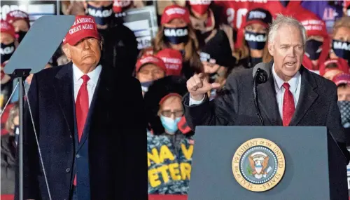  ?? MARK HOFFMAN / MILWAUKEE JOURNAL SENTINEL ?? Sen. Ron Johnson, R-Wis., speaks as President Donald Trump looks on at a campaign appearance Oct. 17, at Southern Wisconsin Regional Airport in Janesville.