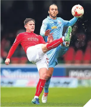  ??  ?? ■ Swindon’s Sean Murray battles for the ball with Tom Thorpe.