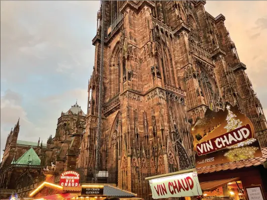  ?? Photo for The Washington Post by Mary Winston Nicklin ?? The Strasbourg Cathedral rises magnificen­tly above the vendors selling vin chaud (mulled wine) at the Christmas market.