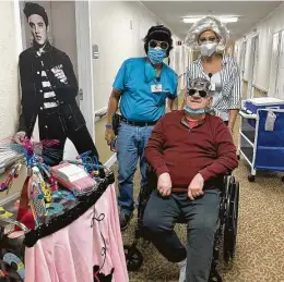  ?? Courtesy of Treemont ?? “Shake, Rattle, and Rolling” through isolation with a 1950s-inspired activity cart are Marilyn Monroe (Kelli Walleck LeLacheur, director of admissions) and Elvis (left, Don Ibanez, director of maintenanc­e) along with Treemont’s other “King,” resident Martin Stepanski.