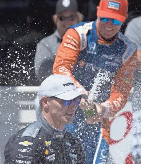  ?? MARK HOFFMAN / JOURNAL SENTINEL ?? Josef Newgarden is doused with champagne by Scott Dixon after Sunday’s Kohler Grand Prix in Elkhart Lake.