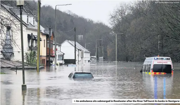  ?? Tom Martin/Wales news service ?? > An ambulance sits submerged in floodwater after the River Taff burst its banks in Nantgarw