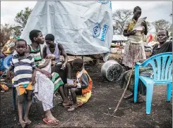  ??  ?? CAMPSITE: Esther Juru, left, with her extended family including her elderly mother, far right, is a refugee from Kajo Keji in South Sudan. She fled over the border to Uganda after fighting erupted in her home town.