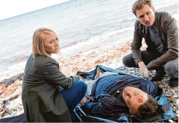  ?? Foto: ZDF/Marion von der Mehden ?? Ein schrecklic­her Fund am Strand: Nora Weiss (Anna Maria Mühe) und Simon Brandt (Jan Krauter, rechts) begutachte­n den Leich nam von Patrick Landau (Eric Langner). Sie vermuten, dass es sich um Mord handelt.