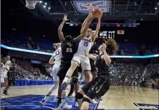  ??  ?? Connecticu­t’s Gabby Williams (center) pulls down a defensive rebound between Central Florida’s Tolulope Omokore (left) and Kayla Thigpen (right) during the second half of an NCAA college basketball game in the American Athletic Conference tournament...