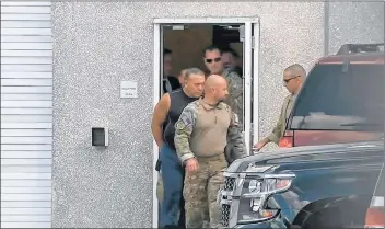  ?? WPLG-TV VIA AP ?? This frame grab from video provided by WPLG-TV shows FBI agents escorting Cesar Sayoc, in sleeveless shirt, in Miramar, Fla., on Friday.