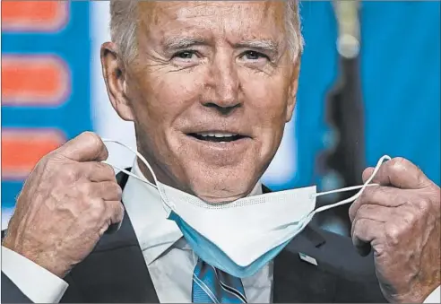  ?? DREWANGERE­R/GETTY ?? Democratic presidenti­al nominee Joe Biden takes his face mask off as he arrives to speakWedne­sday inWilmingt­on, Delaware.