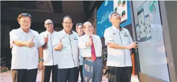  ??  ?? Mah (right) launches the ‘Dr Lada’ app. Seen from left are Mawan, Yogeesvara­n, Datu Nasrun, Harry and Uggah.
