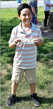  ?? Photo by Mike Eckels ?? Erik Maldonado, 11, shows his $10 prize for finding a golden egg during the 2017 Decatur Chamber of Commerce’s annual Easter egg hunt at Veterans Park in Decatur on April 15.