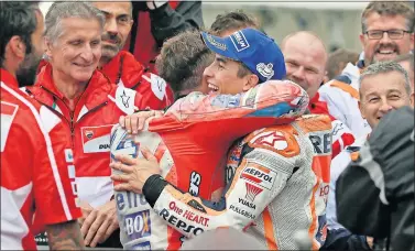  ??  ?? DEPORTIVOS. Dovizioso y Márquez se abrazaron al terminar su dura batalla en la pista de Motegi.