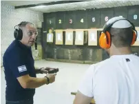 ?? (Marc Israel Sellem/The Jerusalem Post) ?? YAIR YIFRACH, general manager of the Gun Hill shooting range in Givat Ze’ev, north of Jerusalem, gives instructio­ns on the use of firearms this week.