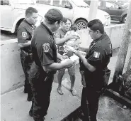  ??  ?? • Elementos de la Policía Estatal dan los primeros auxilios a la joven madre.