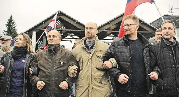  ?? Foto: Petr Lundák, MAFRA ?? V živém řetězu „Bojovníci“z Bloku proti islámu a Úsvitu demonstruj­í svou jednotu na hraničním přechodu v Českých Velenicích. Hlavní ideolog hnutí Petr Hampl (uprostřed ve světlé bundě) včera nečekaně oznámil svou rezignaci. Po jeho pravici lídr Bloku...