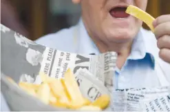  ?? —AFP ?? LONDON: This file photo shows a man posing for a photograph whilst eating a portion of chips in east London.