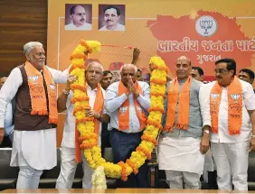  ?? ?? Gujarat Chief Minister Bhupendra Patel being garlanded in the presence of Defence Minister Rajnath Singh and others during a meeting at BJP office, in Gandhinaga­r on Saturday. ANI
