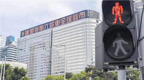  ??  ?? A pedestrian signal shows a red light with the China Evergrande Centre in the background in Hong Kong on Friday.