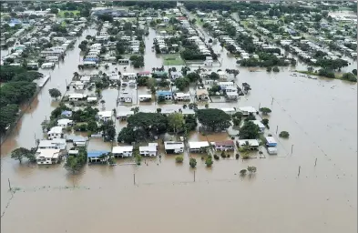  ?? REUTERS ?? Houses can be seen surrounded by flood waters in the town of Ingham in Queensland, Australia, on Sunday. The area has been hit by four days of torrential rain.