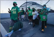  ?? ANDA CHU — STAFF PHOTOGRAPH­ER ?? A’s fan Bryan Johansen, left, who waited outside nearly six hours, enters the Oakland Coliseum from the BART bridge for the Oakland Athletics’ 2021 season-opening game against the Houston Astros on Thursday.