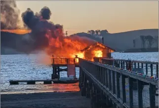  ?? TWITTER.COM — MARINCOUNT­YFIRE ?? A boathouse at Nick's Cove in Marshall burns along the Tomales Bay shore on Sunday.