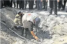  ?? Bezpečnost­ní složky prozkoumáv­ají poškozenou silnici po výbuchu, ke kterému došlo v blízkosti konvoje palestinsk­ého premiéra. FOTO AP ?? Kráter v Gaze.