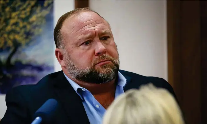  ?? Photograph: Reuters ?? Alex Jones faces questions about his emails from Mark Bankston, lawyer for Neil Heslin and Scarlett Lewis, during the trial on Wednesday.