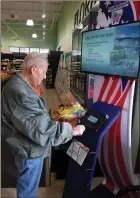  ?? Bennett Horne/The Weekly Vista ?? Pete Rathmell, who is the president of the NWA Veterans Coalition, taps his way through the menus on the screen of the resource kiosk for veterans that was installed at the Harps Grocery Store in Bella Vista on Friday, Jan. 28.