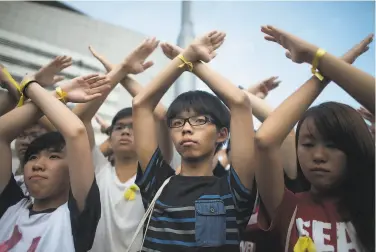  ?? Anthony Kwan / Getty Images 2014 ?? Prodemocra­cy activist Joshua Wong (center) received more jail time for participat­ing in a vigil to commemorat­e the 1989 Tiananmen Square crackdown, as Hong Kong authoritie­s exert more control.