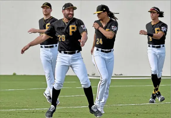  ?? Matt Freed/Post-Gazette ?? From left, Pirates pitcher Chad Kuhl, catcher Francisco Cervelli, pitcher Chris Archer and infielder Cole Tucker warm up before spring training workouts Monday at Pirates City in Bradenton, Fla. See story