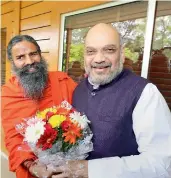  ?? — PTI ?? BJP chief Amit Shah meets yoga guru Baba Ramdev during his campaign to create awareness about the NDA government’s achievemen­ts, in New Delhi